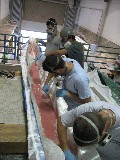 Students fiberglassing an outrigger canoe.